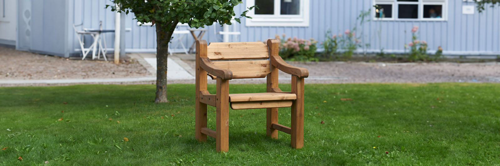 A traditional all wood park chair in a public park space.